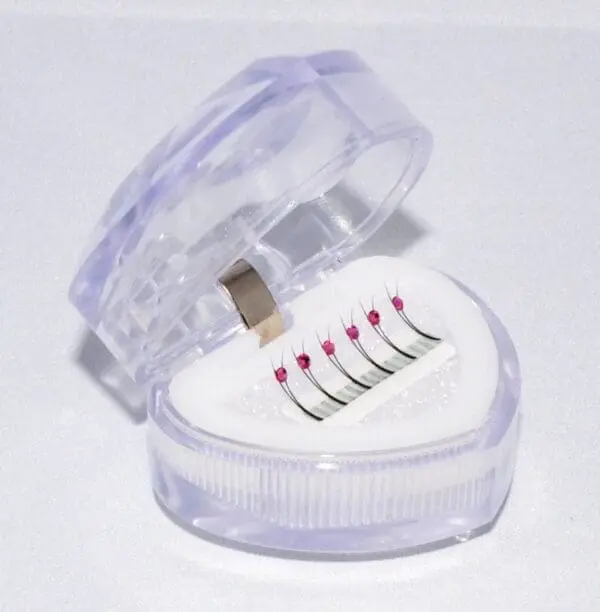 A heart shaped box with six different needles in it.