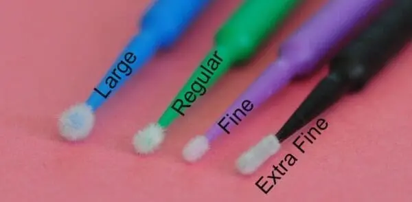 A close up of three different types of toothbrushes