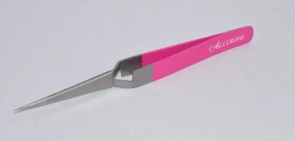 A pink and gray pair of scissors on top of a table.