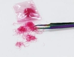 A pair of scissors and some pink hair.