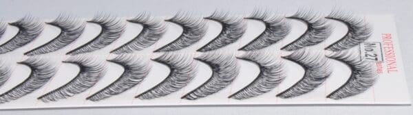 A close up of false eyelashes on top of a white sheet.