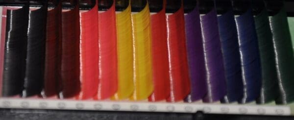 A row of colored pencils sitting on top of each other.