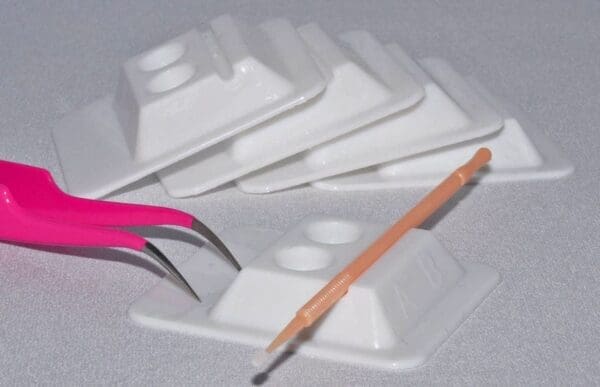 A pair of scissors and pencil are sitting on some white plastic.