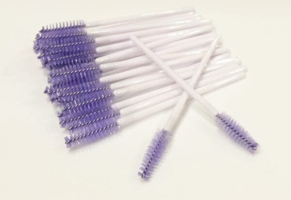 A bunch of purple and white brushes on top of each other.