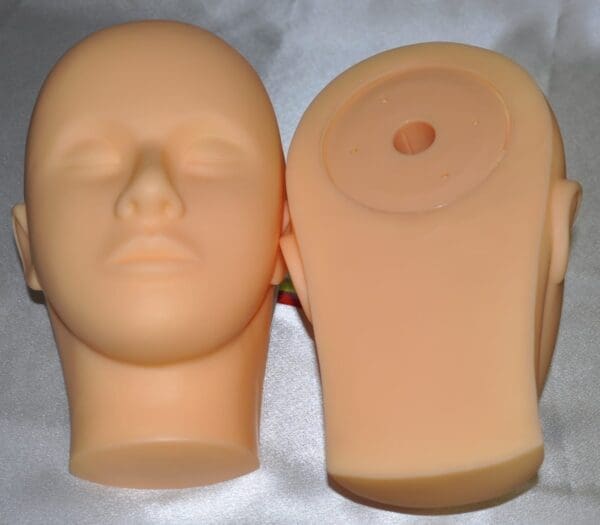 A mannequin head with two different faces on it.