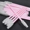 A bunch of pink and white toothbrushes are on the table