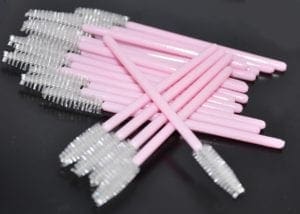 A bunch of pink and white toothbrushes are on the table