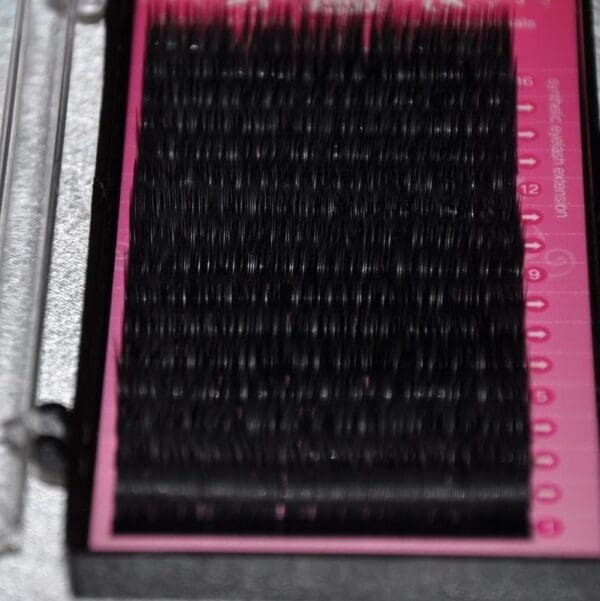 A close up of the black lashes on a pink tray