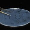 A plate with some black hair being cut