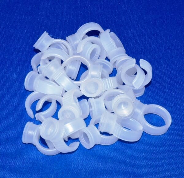 A pile of white plastic rings on top of blue surface.