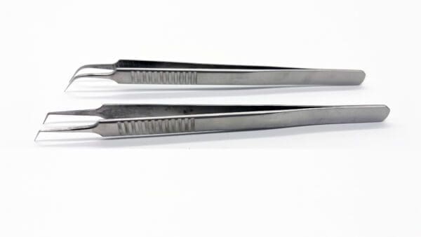 A pair of tweezers are sitting on top of each other.