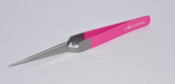 A pink and gray pair of scissors on top of a table.