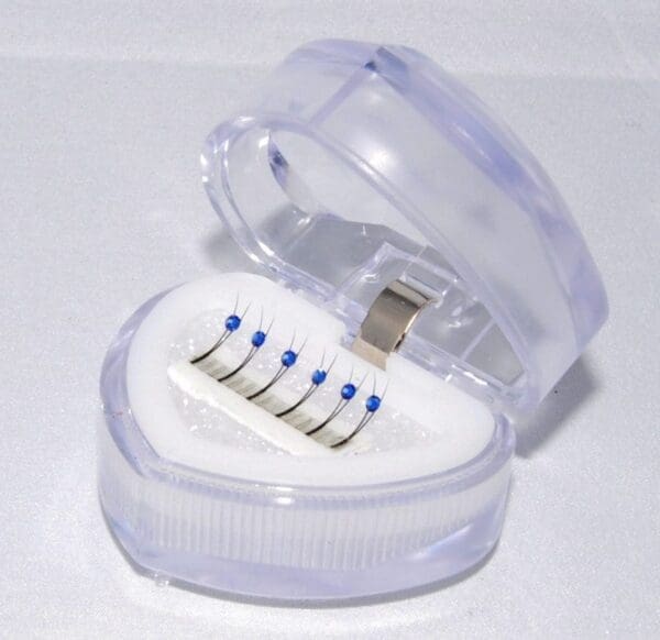 A heart shaped container with six different sized toothbrushes inside.