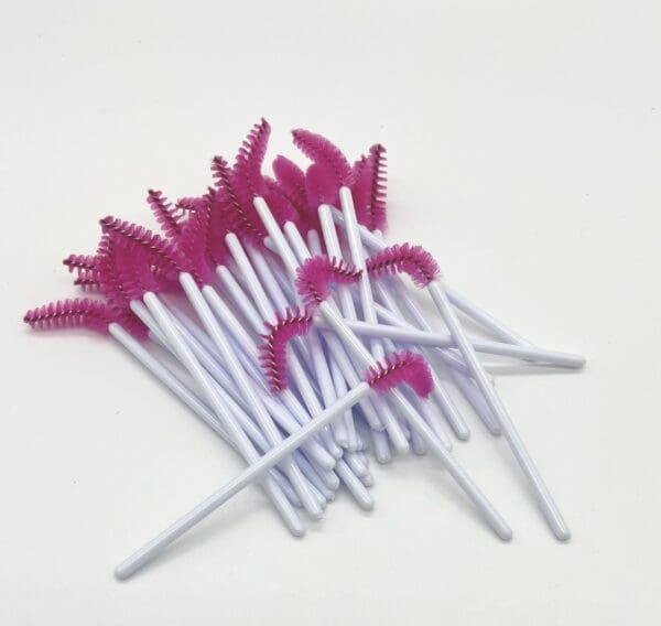 A bunch of pink and white brushes on top of each other.