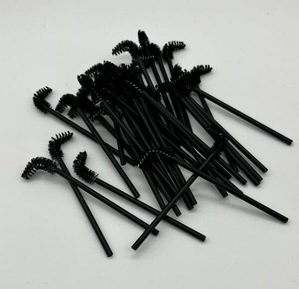 A bunch of black plastic toothbrushes are on the table