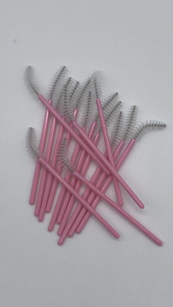 A bunch of pink and silver brushes on top of each other.